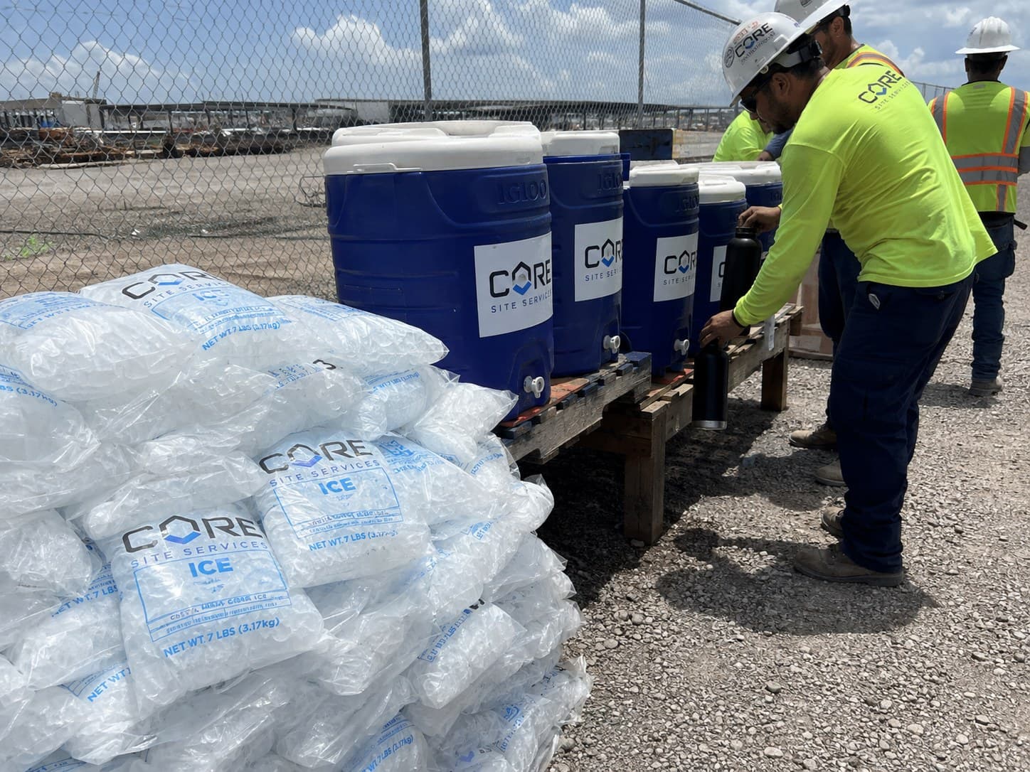 Hydration station with CORE water coolers and bagged ice on a construction job site